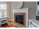Close up of fireplace with white mantel, dark colored tile hearth, clock and decor at 2890 Trillium Way, Columbus, IN 47201
