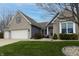 Charming brick home featuring a two-car garage, manicured lawn, and classic architectural details under a beautiful sky at 2890 Trillium Way, Columbus, IN 47201