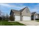 Attached two-car garage showcasing a brick facade, complemented by a well-maintained lawn and clean driveway at 2890 Trillium Way, Columbus, IN 47201