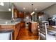 Open kitchen with stainless steel appliances, a center island, and adjacent dining area with stylish hardwood floors at 2890 Trillium Way, Columbus, IN 47201