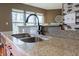 Close up of kitchen sink with granite counters, stylish tile backsplash, and updated fixtures at 2890 Trillium Way, Columbus, IN 47201