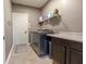 Laundry room featuring a washer and dryer, tiled floors, and a storage shelf at 2890 Trillium Way, Columbus, IN 47201