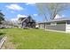 Expansive backyard view of home and garage, with green lawn, stone patio, and an outdoor firepit at 3015 S Rybolt Ave, Indianapolis, IN 46241