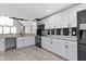 Well-lit kitchen showcases white cabinets, stainless steel appliances, modern backsplash and herringbone-patterned wood flooring at 3015 S Rybolt Ave, Indianapolis, IN 46241