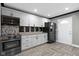 This kitchen is equipped with stainless steel appliances, white cabinets, and a dark-colored refrigerator at 3015 S Rybolt Ave, Indianapolis, IN 46241