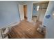 Bedroom featuring hardwood floors, light blue walls, and a closet with mirrored sliding doors at 314 S Taft Ave, Indianapolis, IN 46241