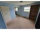 Bedroom with light blue walls, carpeted floors, closet with sliding mirror doors and natural light at 314 S Taft Ave, Indianapolis, IN 46241