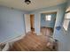 Bedroom with light blue walls, hardwood floors, closet with sliding mirror doors and bright natural light at 314 S Taft Ave, Indianapolis, IN 46241