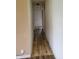 Narrow hallway featuring wood-look floors and neutral paint, connecting various rooms at 314 S Taft Ave, Indianapolis, IN 46241
