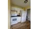 Compact kitchen with white appliances, cabinets, and wood-look floors at 314 S Taft Ave, Indianapolis, IN 46241
