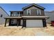 Charming two-story home featuring a two-car garage, covered entry, and dark siding at 3309 Godby Dr, Sheridan, IN 46069