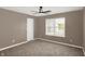 Neutral bedroom features plush carpeting, a ceiling fan, and a bright window at 3529 Miesha Dr, Indianapolis, IN 46217