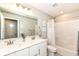 Bathroom featuring white cabinets, dual sinks, shower and tub combination with white tiling at 3650 Tipperlin Rd, Bargersville, IN 46106