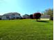 Large backyard with well-manicured lawn, mature trees, and shed offers space for recreation and relaxation at 3730 Cheyenne Ct, Columbus, IN 47203
