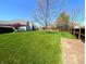 Expansive green backyard with a shed and mature trees is bordered by a wooden fence for added privacy at 3730 Cheyenne Ct, Columbus, IN 47203