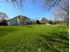 Large, well-maintained backyard with lush green grass, mature trees, and a wooden fence provides privacy at 3730 Cheyenne Ct, Columbus, IN 47203