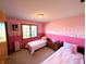 Charming bedroom featuring twin beds, pink walls, and whimsical wall decorations for a cozy feel at 3730 Cheyenne Ct, Columbus, IN 47203