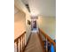 Upstairs hallway with wooden railing and neutral carpet at 3730 Cheyenne Ct, Columbus, IN 47203