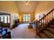 Cozy living room featuring large window, comfortable seating arrangement, vaulted ceiling, and a traditional staircase at 3730 Cheyenne Ct, Columbus, IN 47203