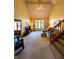 Bright and airy living room features a large window, comfortable furniture, vaulted ceiling, and traditional staircase at 3730 Cheyenne Ct, Columbus, IN 47203