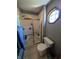 Neutral colored bathroom with a gold framed shower and a small hexagon window at 3730 Cheyenne Ct, Columbus, IN 47203