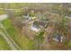 An aerial view of a large home and pool within a residential area nestled amongst mature trees at 3892 Arrowhead Ct, Greenfield, IN 46140