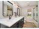 This bathroom has a double sink vanity, black hardware, tile floors, and a shower with glass doors at 3892 Arrowhead Ct, Greenfield, IN 46140
