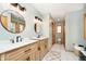 The bathroom features dual sinks, wood vanities, black fixtures, a patterned rug, and a walk in shower at 3892 Arrowhead Ct, Greenfield, IN 46140