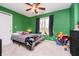 This bedroom features green walls, carpet floors, a ceiling fan, and a window at 3892 Arrowhead Ct, Greenfield, IN 46140