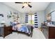 Bedroom with carpet floors, dresser, ceiling fan, and a window with striped curtains at 3892 Arrowhead Ct, Greenfield, IN 46140