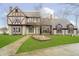 Charming Tudor-style home with a well-manicured lawn and decorative fountain at 3892 Arrowhead Ct, Greenfield, IN 46140
