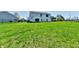 Extensive green backyard with yellow dandelions set against a residential home backdrop at 4064 Waterfield Dr, Indianapolis, IN 46235