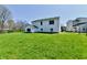 Large, grassy backyard of a white home on a sunny day at 4064 Waterfield Dr, Indianapolis, IN 46235