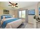 Bright bedroom featuring a ceiling fan, a large window, and a nicely decorated bed with blue accents at 4064 Waterfield Dr, Indianapolis, IN 46235