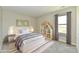 A staged bedroom featuring a bed, shelving, a window with curtains and a rug at 4064 Waterfield Dr, Indianapolis, IN 46235