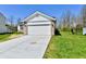 A two-car garage with concrete driveway and adjacent green lawn under a bright blue sky at 4064 Waterfield Dr, Indianapolis, IN 46235