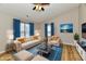 Bright living room features a ceiling fan, two large windows with modern curtains, and comfortable furnishings at 4064 Waterfield Dr, Indianapolis, IN 46235