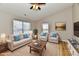 Bright living room features a ceiling fan, two large windows, and comfortable furnishings arranged on a decorative rug at 4064 Waterfield Dr, Indianapolis, IN 46235