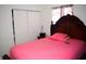 Comfortable bedroom with a pink bedspread, closet, and natural light from the window at 4107 Eisenhower Dr, Indianapolis, IN 46254