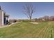 Well-maintained backyard featuring a sprawling lawn, mature tree, and partial fencing at 4140 Omaha Dr, Bargersville, IN 46106