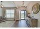 Inviting entryway with a decorative mirror, wood floors, modern chandelier, console table and a view into the front yard at 4140 Omaha Dr, Bargersville, IN 46106