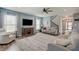 Bright living room with hardwood floors, a TV, large windows, and a staircase leading to the upper level at 4140 Omaha Dr, Bargersville, IN 46106