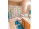 Cozy bathroom with tile flooring, a single sink vanity, framed mirror, and a tub-shower combo with leafy shower curtain at 498 Lake Shore Ct, Franklin, IN 46131
