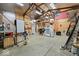 Spacious garage with a high ceiling, wood beams, storage areas, and an American flag on the wall at 501 S John St, Arcadia, IN 46030