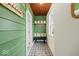 Hallway with hooks, a bench, a window, green siding, and black and white checkered flooring at 501 S John St, Arcadia, IN 46030