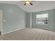 Bright bedroom with plush carpeting, a ceiling fan, and a window offering neighborhood views at 503 Fayette Dr, Westfield, IN 46074