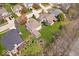Aerial view of houses and a backyard featuring a serene pond, lush lawn, landscaping, and mature trees in a tranquil community at 5343 Ripplingbrook Way, Carmel, IN 46033
