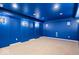 Home theater room featuring a blue color scheme, carpet flooring, and sconce lighting at 5343 Ripplingbrook Way, Carmel, IN 46033