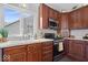 Kitchen features modern appliances, white countertops, hardwood cabinets, and a large window at 5343 Ripplingbrook Way, Carmel, IN 46033