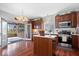 Kitchen with stainless steel appliances, hardwood floors, an island, and a sunroom with nature views at 5343 Ripplingbrook Way, Carmel, IN 46033